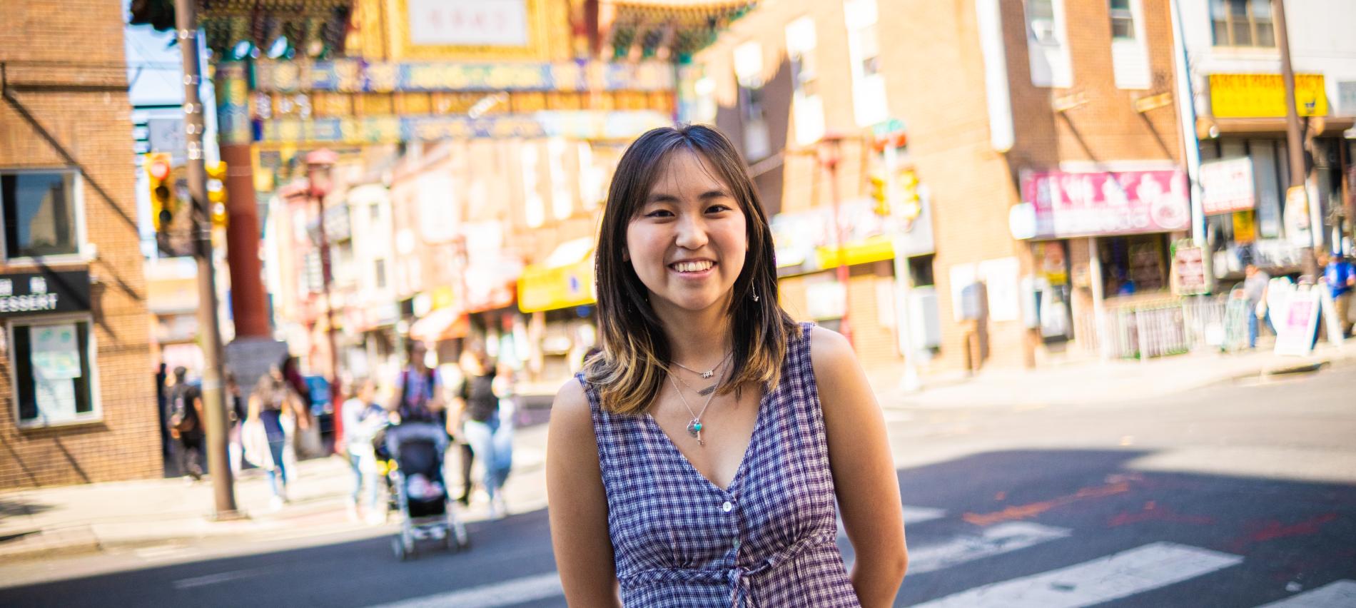 Kaia Chau standing in front of the Philadelphia Chinatown Gates